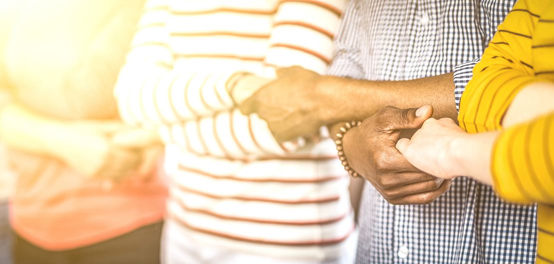 Image of multiple people linking arms
