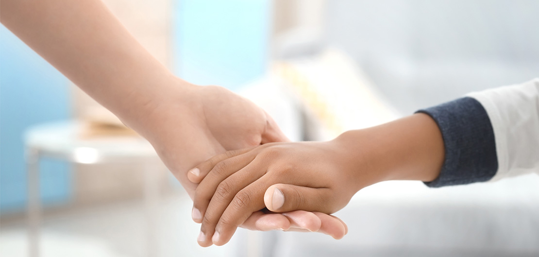 Image of two people holding hands.
